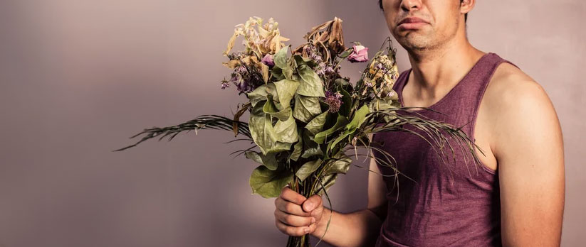 A man holding a bouquet of flowers.